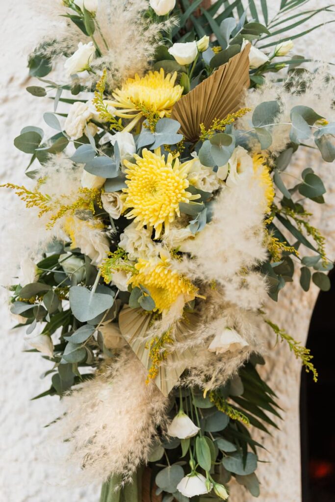 Λεπτομέρεια με κίτρινα λουλούδια και ευκάλυπτο σε βάπτιση